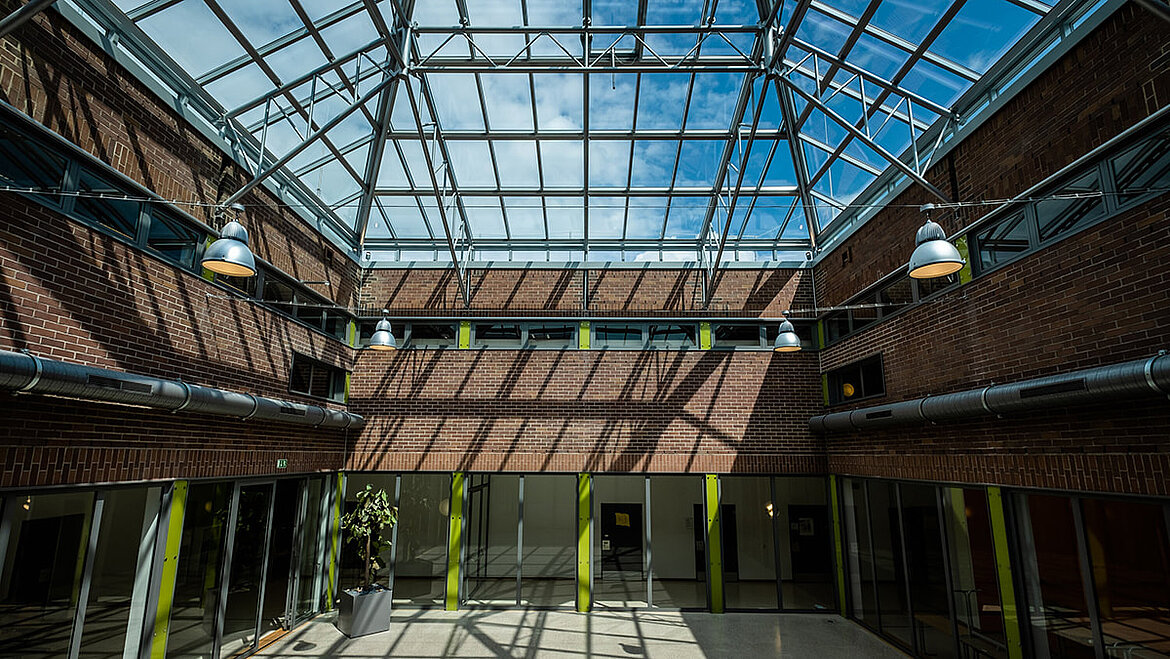 Cour intérieure inondée de lumière naturelle du lycée Dante à Munich Rénovation d'un toit en verre avec le système poteaux-traverses de LAMILUX | insights by LAMILUX