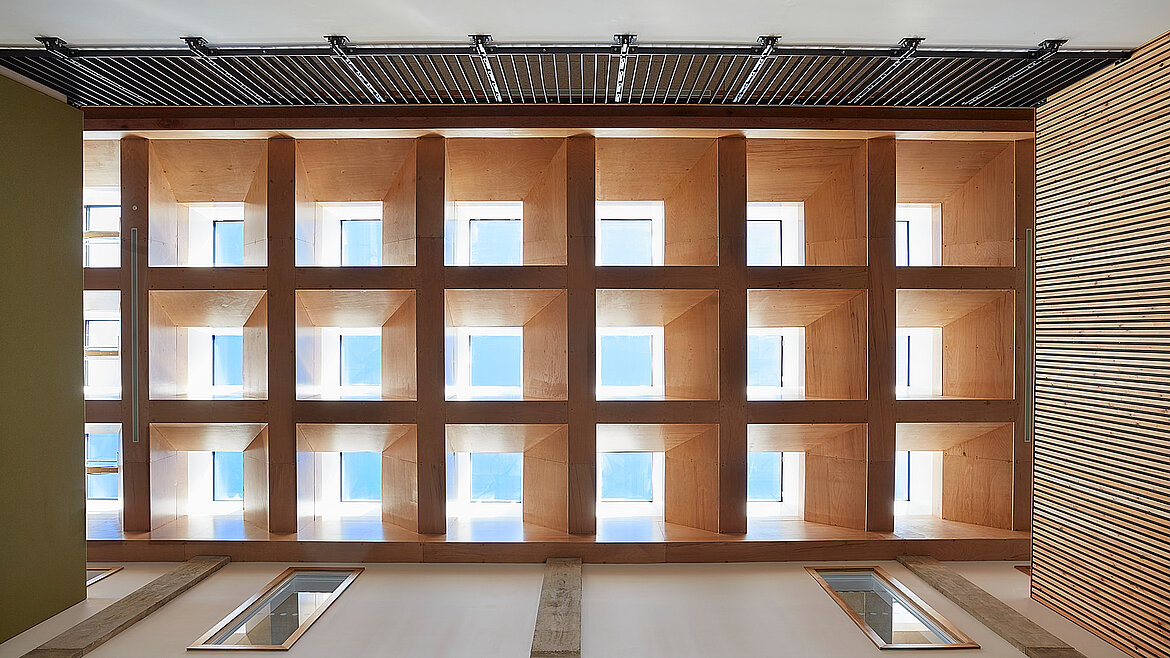 Decke mit quadratischen Oberlichtern in Holzrahmen und künstlerischen Wandmustern.